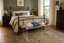 clothing on top of clear acrylic table in bedroom